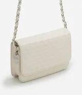 Bolso estructurado de Satinato color blanco, con textura capitoneada, solapa frontal y correa de cadena dorada.