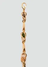Cinturón fino de metal dorado con detalles de abalorios de colores distribuidos a lo largo de la cadena.
