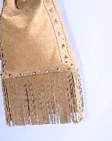 Cartera tipo shoulder bag de cuero color suela, con diseño decorado con tachas metálicas y flecos largos en la parte inferior. Cuenta con correa ajustable y compartimento principal espacioso.