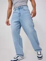 Jean de corte loose fit en color azul claro, con diseño de cinco bolsillos, cierre frontal con botón y bragueta, y costuras reforzadas.