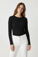 Remera de manga larga color blanco hueso, de tejido acanalado y corte ajustado al cuerpo, con cuello redondo.