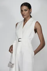 Mono largo de lino blanco, con escote en V, sin mangas, cinturón con hebilla forrada y pantalón palazzo.