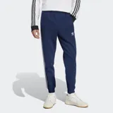 Pantalón de jogging azul marino con tres rayas blancas a los costados y logo de Adidas bordado en el muslo.