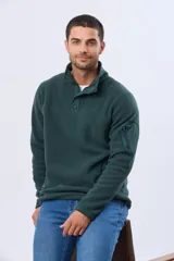 Buzo de abrigo confeccionado en tejido polar térmico, con cuello alto y cierre frontal parcial con broches. Presenta bolsillos laterales con cierre y un bolsillo adicional con cierre en la manga izquierda.