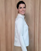 Polera de manga larga color blanco, confeccionada en algodón, con cuello alto tipo tortuga y detalles de volados en el cuello y en los puños.