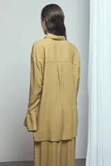 Camisa de viscosa con estampado de rayas verticales en tonos rosado y marrón, de corte oversize, con cuello camisero, cierre frontal de botones y mangas largas acampanadas.