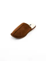 Pantuflas de gamuza color marrón con interior de corderito sintético blanco y costura central reforzada.
