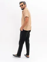 Pantalón chino de corte regular y tiro medio, con bolsillos laterales y traseros, cierre de botón y cremallera, y terminación recta.