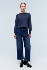 Sweater azul marino de tejido de punto con cuello redondo y mangas largas. Presenta pequeños apliques brillantes en el frente y la espalda.