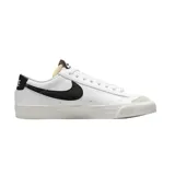 Championes Nike Blazer Low 77 de corte bajo, con capellada de cuero blanco, logo Swoosh lateral en negro y refuerzo de gamuza en la puntera. Presenta suela de goma con textura y lengüeta con espuma expuesta.