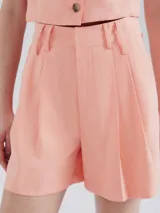 Short de vestir rosado con pinzas, bolsillos laterales y trabillas para cinturón.