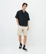 Bermuda slim de sarga color beige, con cintura con trabilla, cierre tradicional y bolsillos laterales.