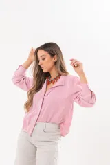 Camisa de manga larga con diseño a rayas rojas y blancas, cuello camisero y cierre frontal con solapa.