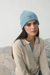 Gorro tipo beanie de punto acanalado en color celeste, con parche bordado de la bandera de Uruguay en el frente.