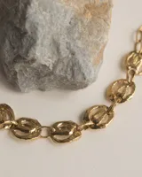 Pulsera de eslabones circulares con diseño orgánico y textura irregular, elaborada artesanalmente en metal con acabado dorado.