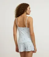 Conjunto de pijama short doll de punto, estampado de cuadros vichy celestes y blancos con mini corazones negros. Incluye un top de breteles finos con escote en V y un short con cintura elástica.