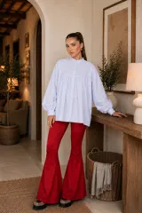 Camisa blanca de algodón con cuello mao, corte amplio, mangas largas abullonadas con puños abotonados y detalle de canesú con pliegues en el pecho.