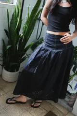 Falda larga negra con diseño de caderín y tablas.