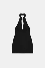 Vestido corto de cuello halter con abertura frontal y lazada, espalda descubierta y falda con bajo acabado en volumen. Cuenta con cierre de cremallera oculto en la espalda y forro interior.