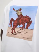 Remera de manga corta y cuello redondo con calce holgado. Presenta una estampa trasera con diseño de un jinete sobre un caballo en tonos tierra y azul. Confeccionada en jersey peinado de algodón.