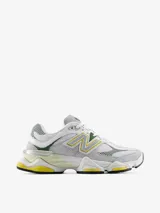 Championes New Balance modelo 9060, con diseño de inspiración Y2K. Presentan una parte superior de malla blanca con superposiciones de gamuza gris y detalles en verde y amarillo. Incluyen el logotipo N característico en los laterales, mediasuela con amortiguación ABZORB y SBS, y dispositivo CR translúcido en el talón.