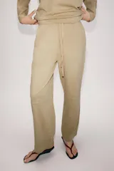 Pantalón balloon de tiro alto confeccionado en algodón, con cintura elástica ajustable mediante cordones tono sobre tono y bolsillos en el delantero.
