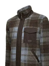 Campera polar de sherpa con estampado a cuadros en tonos marrón y azul. Presenta cierre frontal completo, cuello alto, bolsillo en el pecho con solapa y bolsillos laterales, con detalles en tela canvas en contraste.