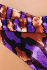 Bombacha de bikini con diseño tipo corset, caracterizada por una faja ancha cruzada en la cintura. Presenta un estampado botánico con hojas en tonos púrpuras y cobrizos, con un corte en V que estiliza la figura.