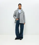 Pantalón wide leg de tiro alto en denim azul oscuro, con trabillas para cinturón, cierre de botón y cremallera, y bolsillos delanteros y traseros.