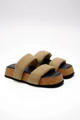 Sandalias planas Free People modelo Fairmount Flared, con plataforma de corcho acampanada, plantilla negra y dos tiras acolchadas anchas de cuero color beige.