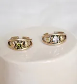 Anillo de bronce con diseño abierto y una zirconia verde engarzada.