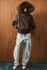 Chaqueta bomber de efecto piel en color marrón oscuro, con cuello subido, cierre frontal cruzado con botones a presión, bolsillos laterales y bajo elástico.