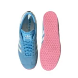 Championes Adidas modelo Gazelle, edición especial Inter Miami CF. Confeccionados en gamuza color celeste con las icónicas tres tiras laterales en blanco y suela de goma en color rosado. Presenta el nombre Gazelle en letras rosadas en el lateral y detalle en blanco en el talón.
