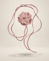 Accesorio de cuero en forma de flor con pétalos superpuestos y tiras largas ajustables, diseñado para usarse como collar, gargantilla o cinto.