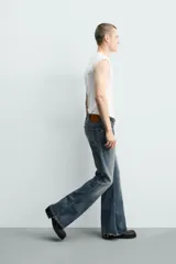 Jeans flare fit de tiro medio, confeccionados en denim de algodón color azul con efecto deslavado. Diseño ajustado en la parte superior y abierto en campana desde la rodilla, con cinco bolsillos y cierre frontal con cremallera y botón.