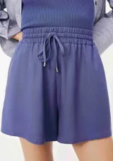 Short de lino color lila, con cintura elástica fruncida y cordón ajustable con punteras metálicas. Presenta un diseño de tiro alto y corte holgado.
