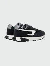 Zapatillas deportivas Diesel modelo S-Tyche D, color negro con detalles en blanco y gris. Presentan una silueta de running retro con paneles de malla y gamuza, entresuela gruesa blanca y suela exterior negra. El logo lateral es una 'D' estilizada en blanco.