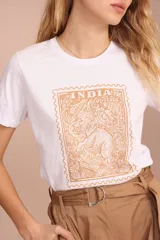 Remera blanca de algodón con cuello redondo y estampado frontal de un sello postal color ocre con un elefante.