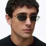 Lentes de sol con montura metálica dorada y lentes rectangulares de color verde oscuro. Diseño minimalista y ligero con terminaciones en acetato.