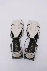 Sandalias de cuero estilo jaula en color rojo, con punta cuadrada, taco cuadrado bajo en color negro y cierre con hebilla ajustable en el tobillo.