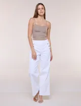 Pantalón de denim blanco de tiro alto y corte wide leg, con bolsillos diagonales decorados con botones metálicos a los lados y piernas de caída recta.