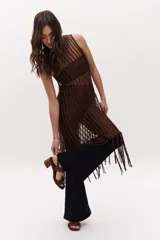 Sandalias de cuero color marrón con dos tiras horizontales, una sobre los dedos y otra sobre el empeine, ambas decoradas con tachas. Tienen taco cuadrado de madera y cierre con hebilla.