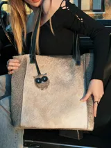 Bolso shopper de pelo color gris con detalle de aplique en forma de búho.