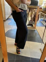 Pantalón ancho de tiro alto, color azul marino, confeccionado en lycra de algodón. Presenta bolsillos delanteros y traseros, y una faja ancha que estiliza la figura.