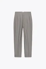 Pantalón blanco de vestir, de tiro alto y corte recto. Presenta bolsillos delanteros de vivo y cierre frontal con cremallera, botón interior y gancho metálico.