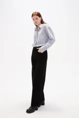 Pantalon de jean negro de corte ancho y tiro alto, con cierre frontal y bolsillos laterales.