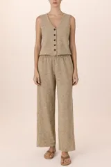 Conjunto de dos piezas confeccionado en tejido de punto color beige melange. Incluye un chaleco con escote en V y cierre frontal de botones, y un pantalón de corte recto con cintura elástica.