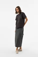 Remera de algodón con calce relajado, color negro lavado, cuello redondo y mangas cortas. Presenta una estampa floral bordada en líneas blancas en el frente.