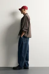 Pantalón jeans de corte relaxed fit, color celeste con efecto lavado, de estilo carpintero con bolsillos laterales y presillas de herramientas.