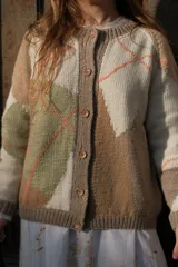 Cárdigan de punto tejido a mano con diseño de rombos en tonos neutros, beige y verde suave. Presenta escote redondo, cierre frontal con botones y mangas largas con diseño holgado.